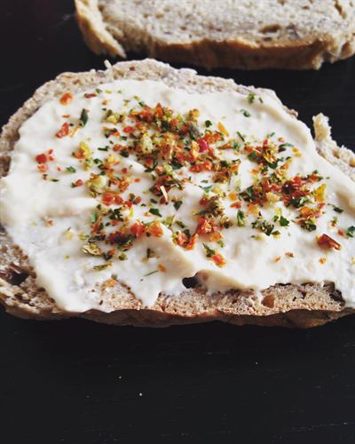 Tartines de pain aux céréales, houmous et herbes de Provence