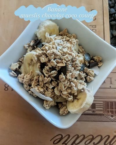 Bol banane, muesli, chocolat noir, coco et graines de courge