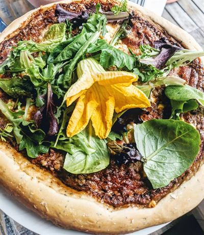 Pizza à la pâte au pavot, tomates, chèvre et herbes fraîches