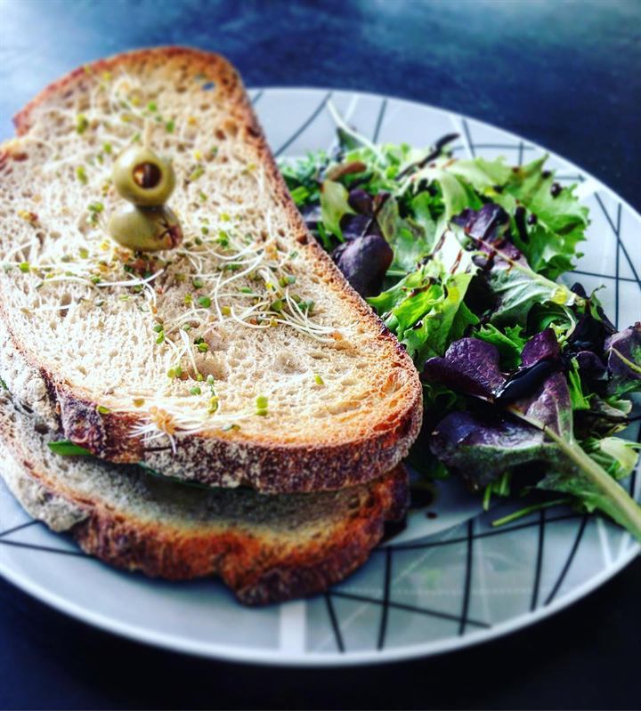 Tartines au fromage aux herbes, pousses d'épinards et roquette