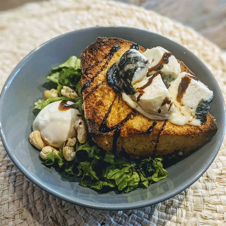 Salade verte, œuf mollet et crottin sur pain au maïs