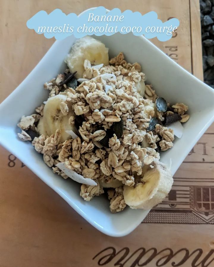 Bol banane, muesli, chocolat noir, coco et graines de courge