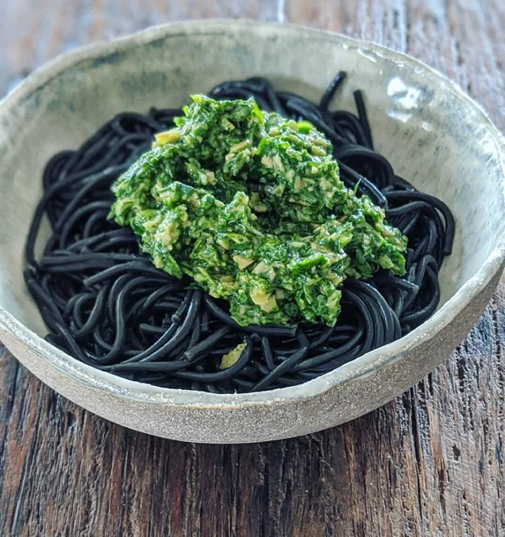 Spaghetti à l'encre de seiche, pesto de roquette, mâche et olives