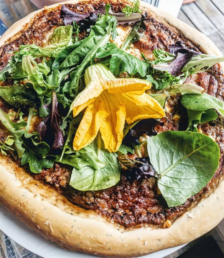 Pizza à la pâte au pavot, tomates, chèvre et herbes fraîches